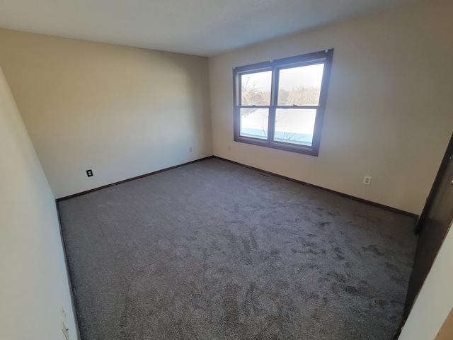 empty room with dark colored carpet