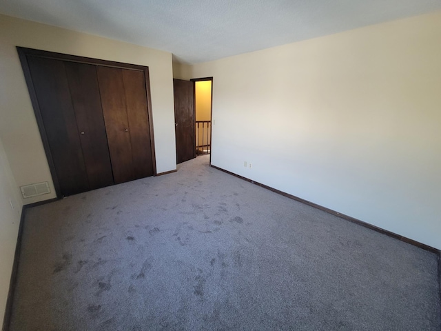 unfurnished bedroom with light colored carpet and a closet