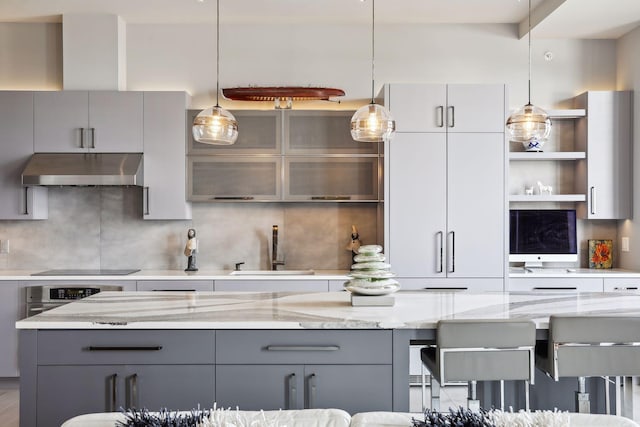 kitchen with gray cabinets, pendant lighting, and exhaust hood