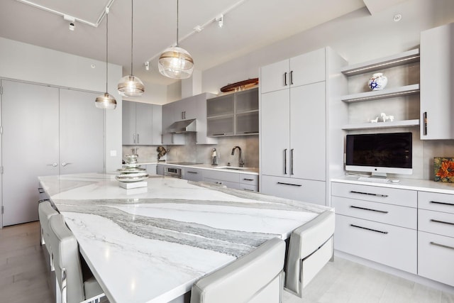 kitchen featuring sink, gray cabinetry, decorative light fixtures, track lighting, and a large island