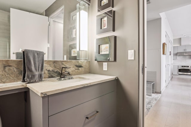 bathroom featuring vanity and backsplash