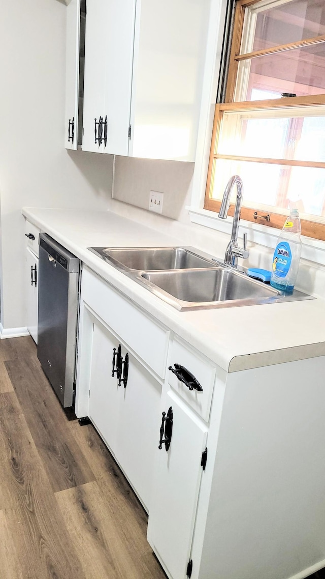 kitchen with sink, dark wood-type flooring, dishwasher, and white cabinets