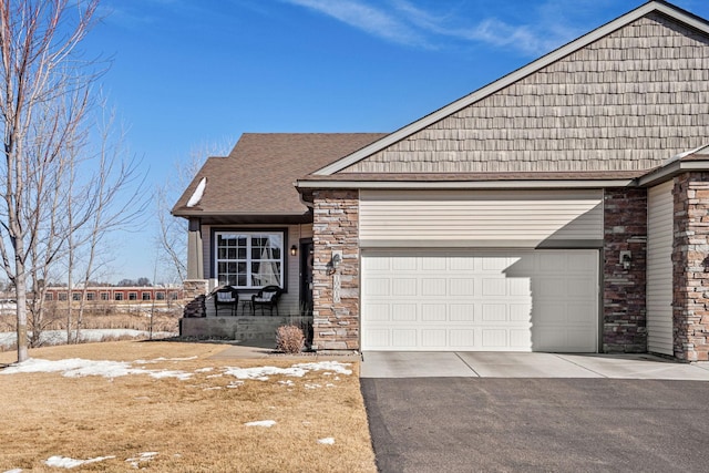 view of front of property with aphalt driveway, stone siding, and an attached garage