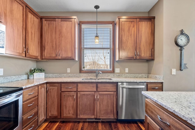 kitchen featuring a sink, dark wood finished floors, brown cabinets, and stainless steel appliances