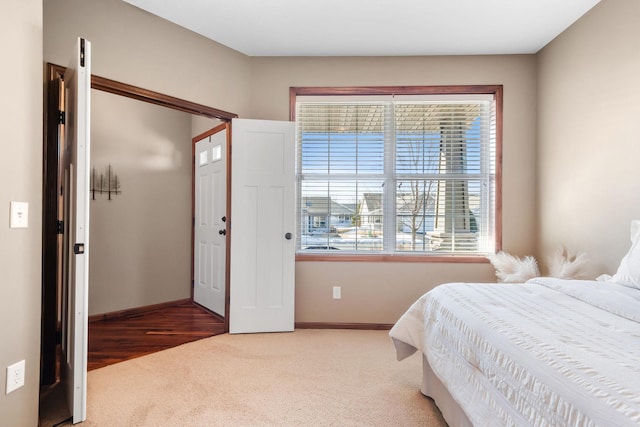 carpeted bedroom featuring baseboards and a closet