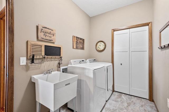 washroom featuring washer and dryer, laundry area, and a sink