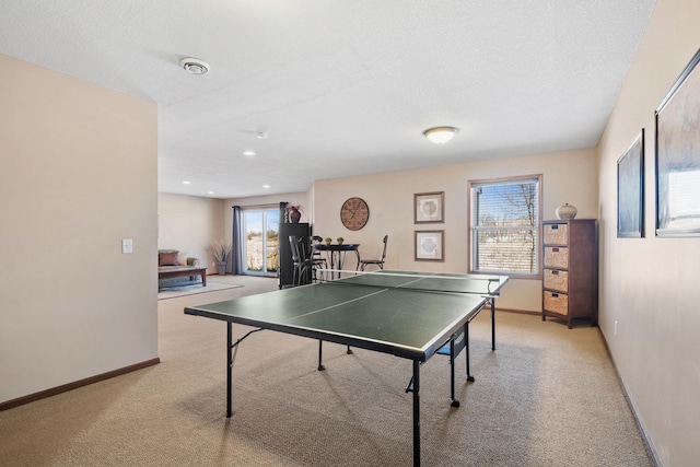 game room with recessed lighting, light colored carpet, a textured ceiling, and baseboards