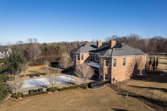 rear view of house with a balcony and a lawn