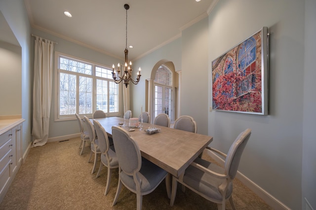 dining room featuring crown molding, light carpet, and a chandelier