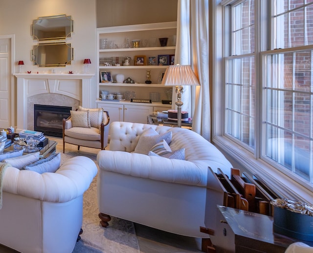 living room featuring a high end fireplace and built in features