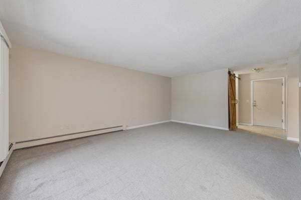 carpeted empty room featuring a baseboard radiator