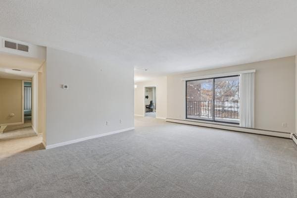 carpeted spare room with baseboard heating