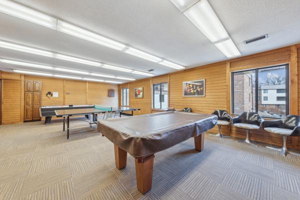 playroom with pool table, wooden walls, and light carpet