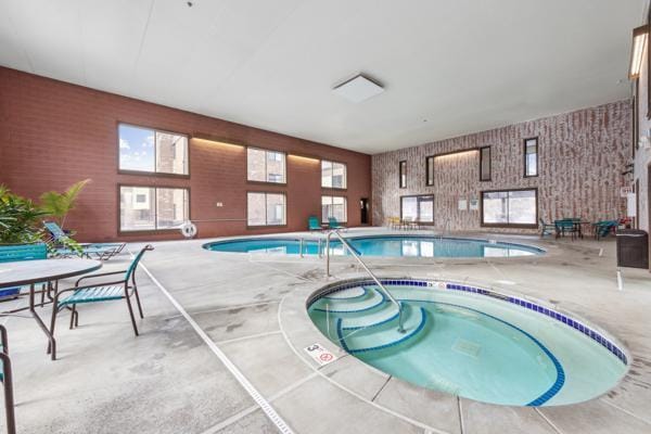 view of swimming pool featuring an indoor hot tub