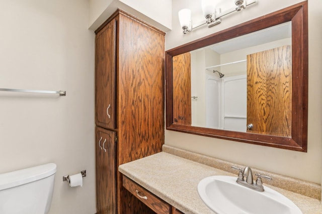 bathroom featuring a shower, vanity, and toilet