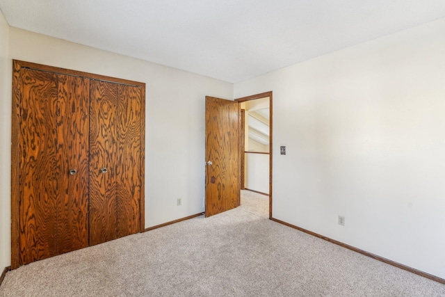 unfurnished bedroom with light carpet and a closet