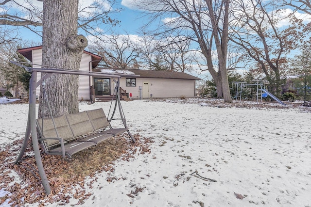 snow covered property with a playground