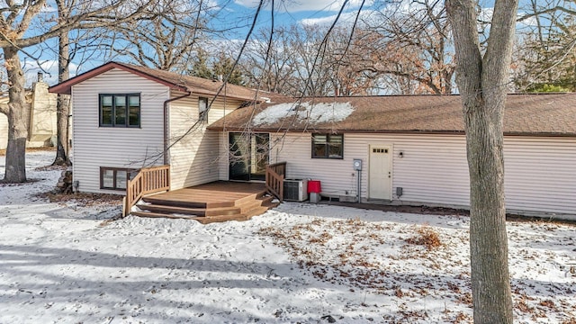 snow covered house featuring central AC unit