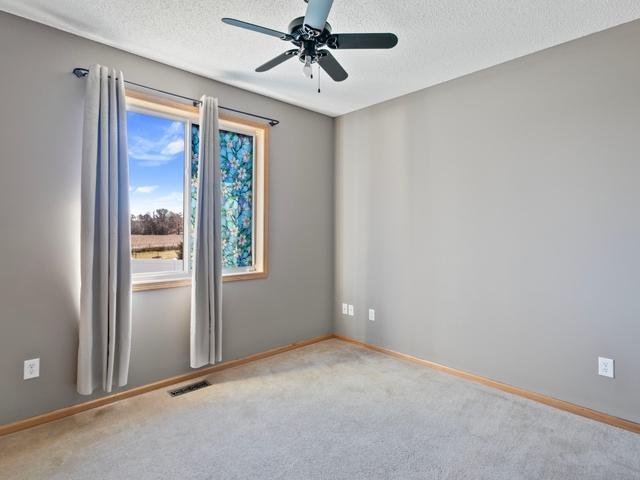 carpeted empty room featuring a textured ceiling and ceiling fan