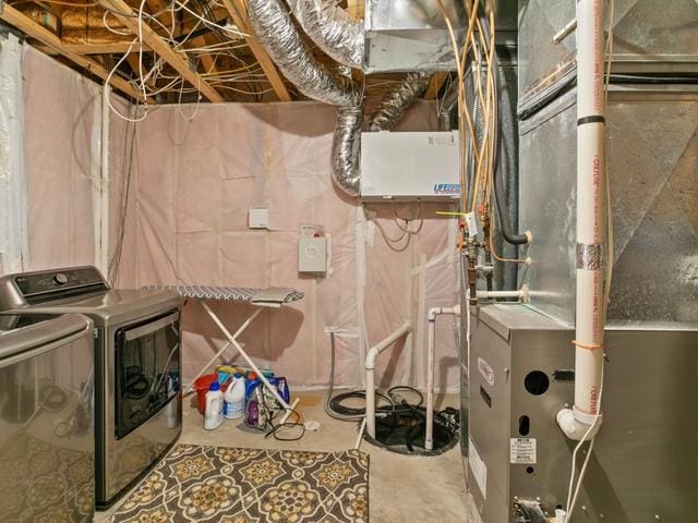 utility room with washing machine and clothes dryer and heating unit