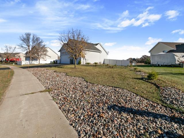 view of property exterior featuring a residential view, a yard, an attached garage, and fence