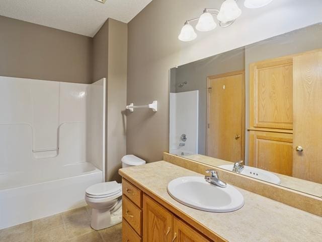 bathroom with  shower combination, vanity, toilet, and tile patterned floors