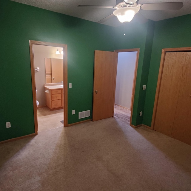 bedroom featuring connected bathroom, carpet floors, visible vents, a ceiling fan, and a closet