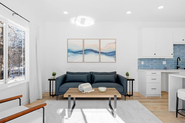 living room with light hardwood / wood-style floors and sink