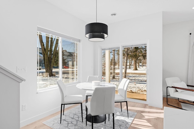 dining space featuring light wood-type flooring and a wealth of natural light