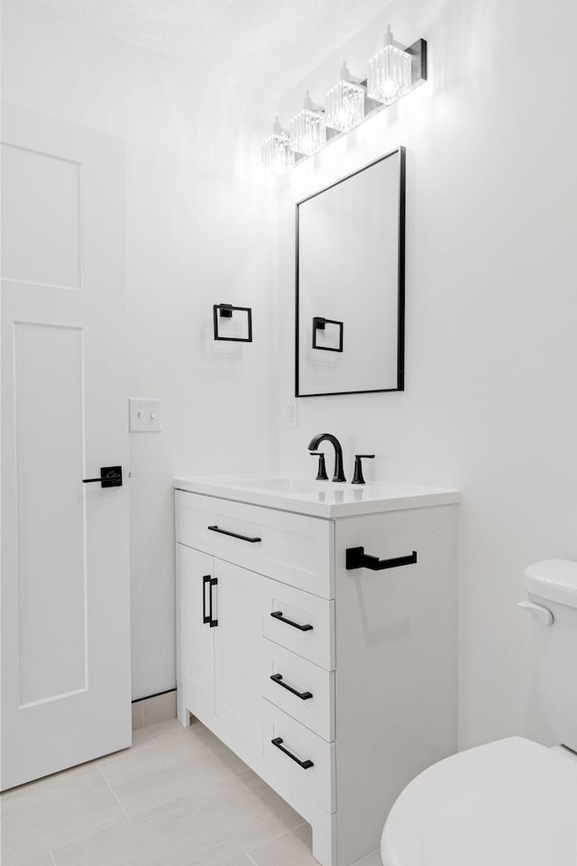 bathroom featuring tile patterned floors, vanity, and toilet