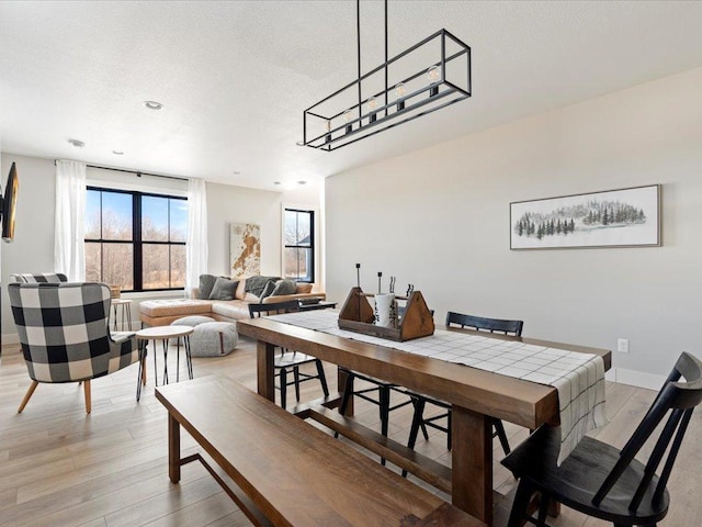 dining space with a textured ceiling and light hardwood / wood-style floors