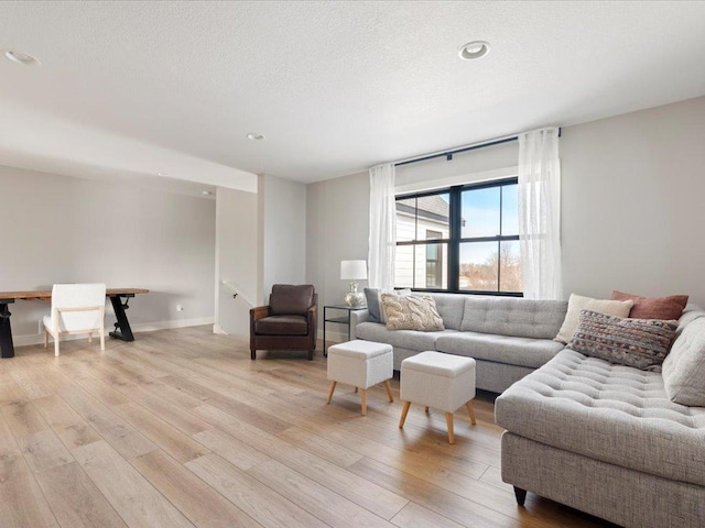 living room with light hardwood / wood-style floors and a textured ceiling