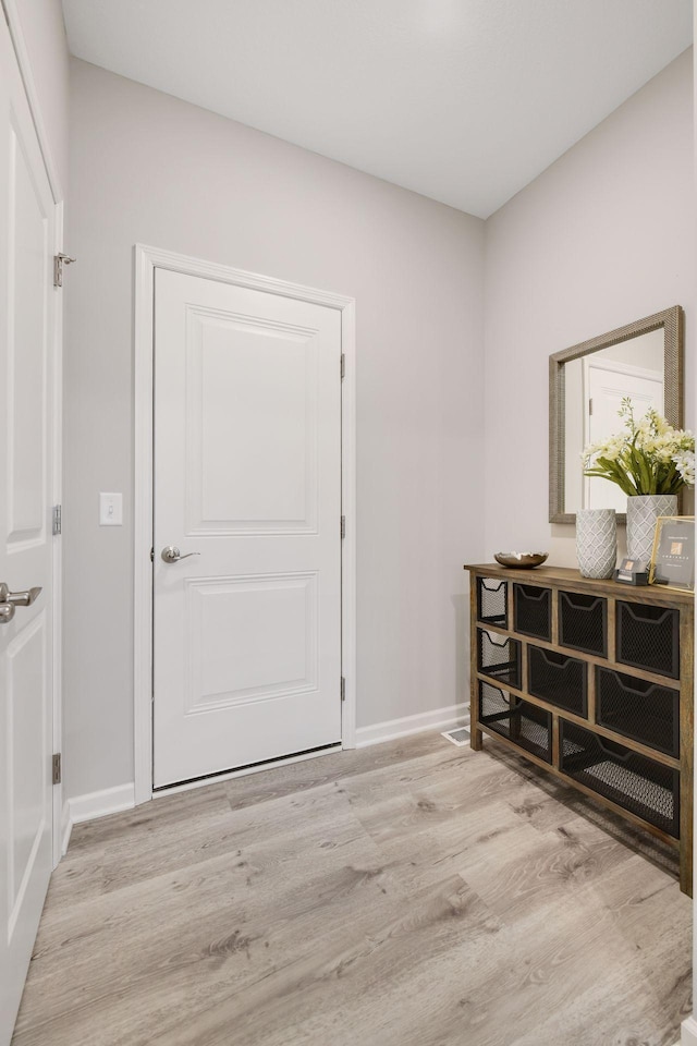 foyer entrance featuring light wood-style floors and baseboards