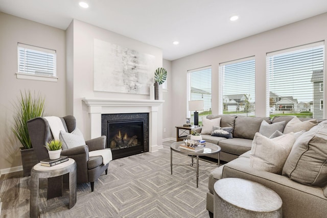 living area with recessed lighting, a glass covered fireplace, and a healthy amount of sunlight