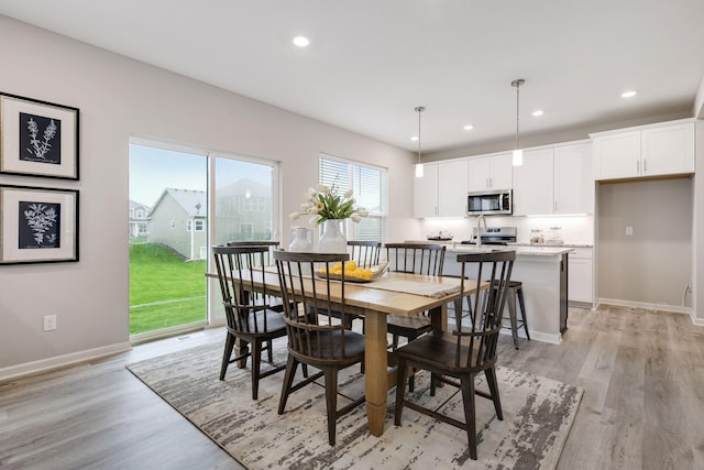 dining area with recessed lighting, light wood-style flooring, and baseboards