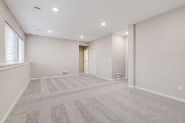 empty room with recessed lighting, visible vents, and baseboards