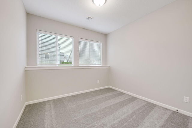 spare room with baseboards and carpet flooring