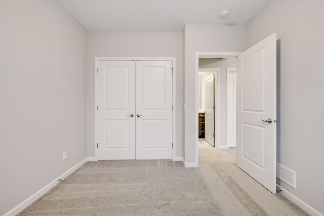 unfurnished bedroom featuring light carpet, visible vents, and baseboards