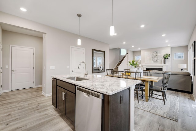 kitchen featuring a sink, dark brown cabinetry, a fireplace, and dishwasher