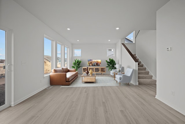 living room with stairs, light wood finished floors, baseboards, and recessed lighting