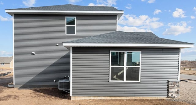 view of home's exterior with roof with shingles and cooling unit