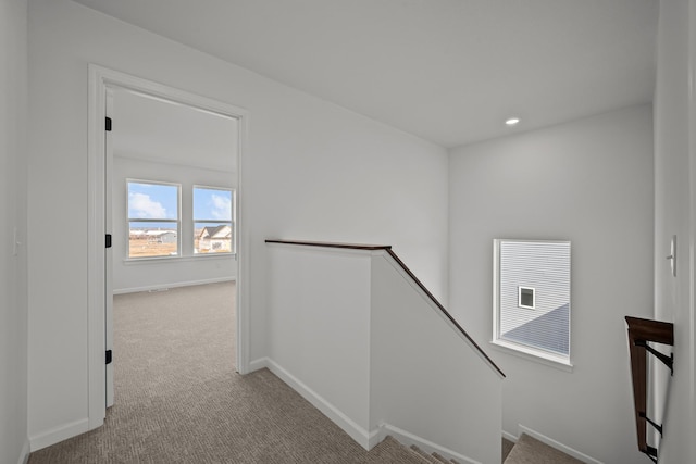 hall with carpet, baseboards, an upstairs landing, and recessed lighting