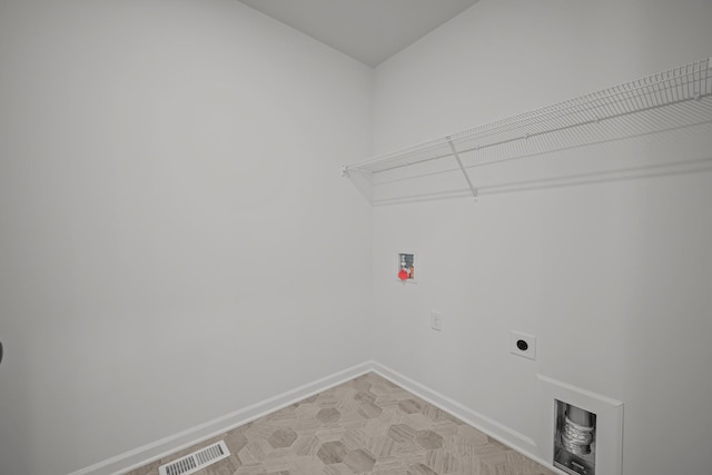 clothes washing area with laundry area, baseboards, visible vents, washer hookup, and electric dryer hookup