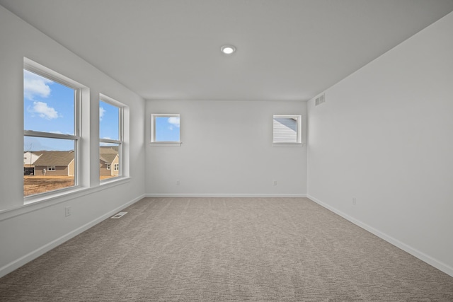 carpeted spare room featuring recessed lighting, visible vents, and baseboards