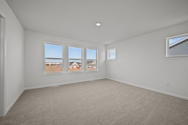 carpeted spare room featuring baseboards