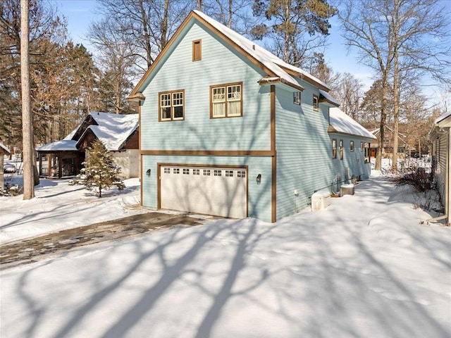 snow covered property featuring a garage