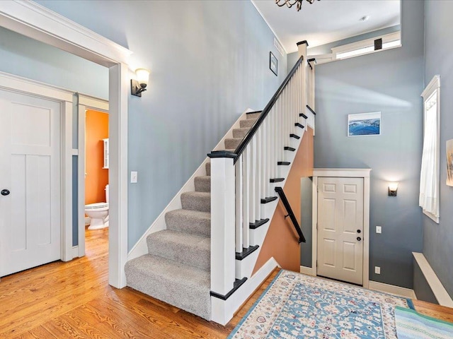 staircase with baseboards and wood finished floors