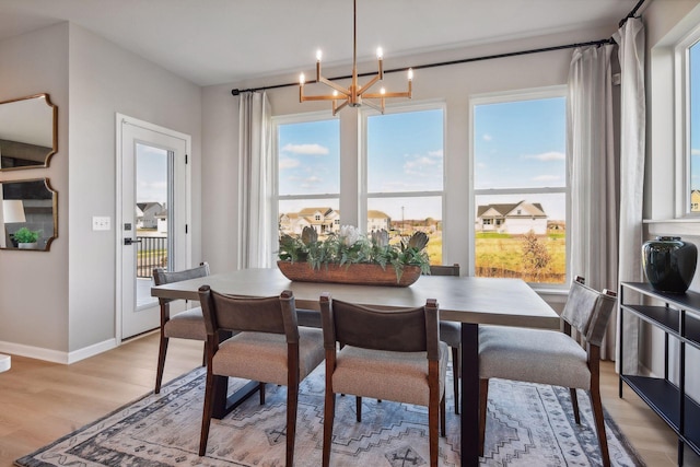 dining space with an inviting chandelier, light hardwood / wood-style flooring, and plenty of natural light