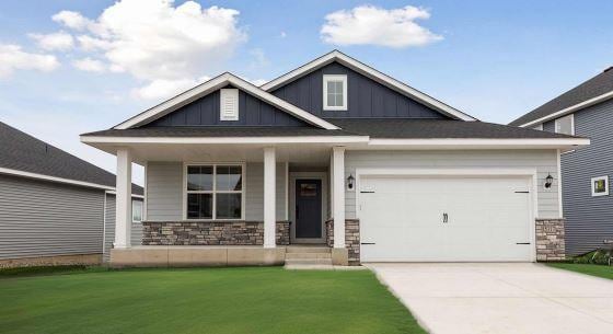 craftsman inspired home with a garage and a front yard