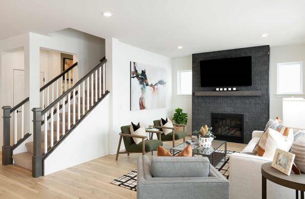 living room with light wood-type flooring, a brick fireplace, and a healthy amount of sunlight